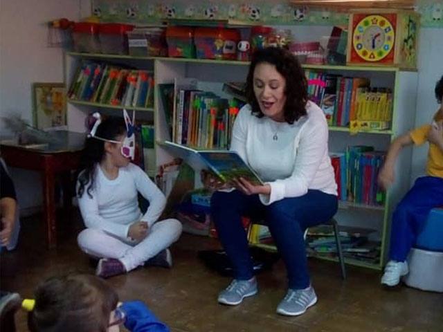 Educadora acompañando a niños en actividades pedagógicas de Mi Rincón Mágico