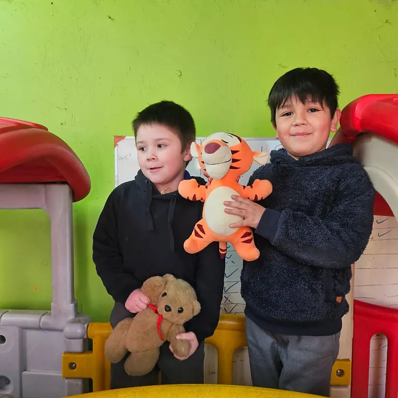 Dos niños con sus peluches en las casitas del patio