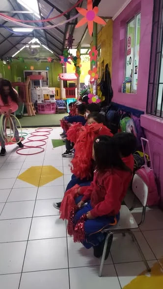 Párvulos con pompones alentando a su alianza en el aniversario N°17