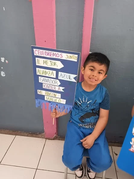 Niño con la pancarta Celebremos juntos de la Alianza Azul en el aniversario N°18