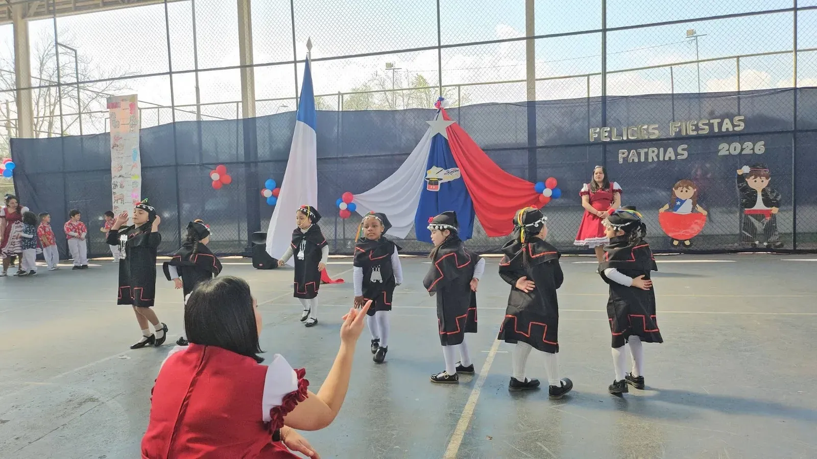 Párvulos con traje típico presentando danza frente al telón de Fiestas Patrias 2026